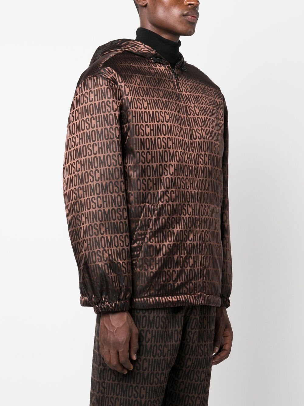 Áo khoác nịt nắng MOSCHINO COUTURE nam màu nâu gỗ nhẹ với họa tiết logo trên toàn bộ