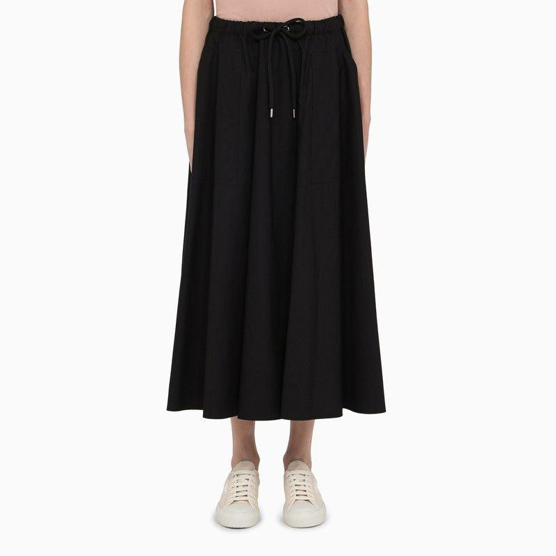 Chân váy dài bằng vải cotton đen với phần thân lưng thun và túi