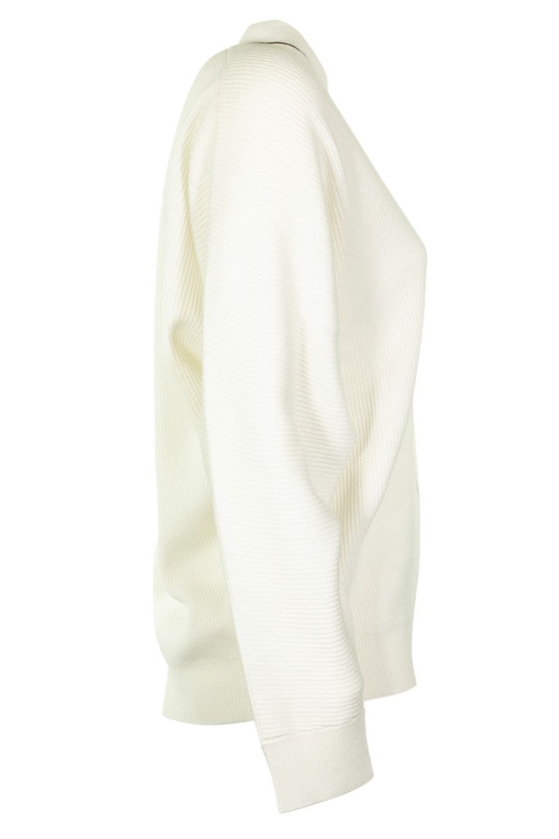 現代白色V領羊毛衫，配備閃亮的莫尼利點綴